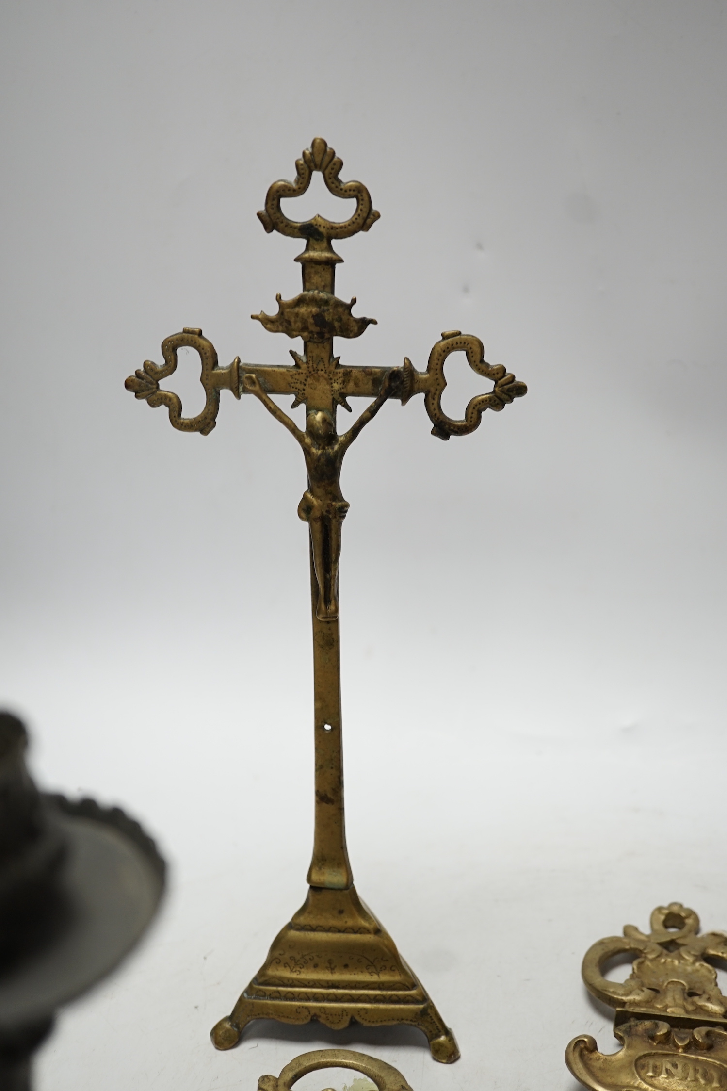 Three brass crucifixes and an Orivit pewter candlestick, tallest 45cm high
